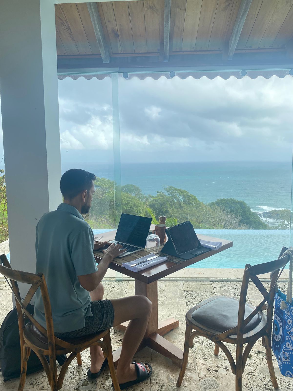 Sean Ali working from an ocean-view balcony